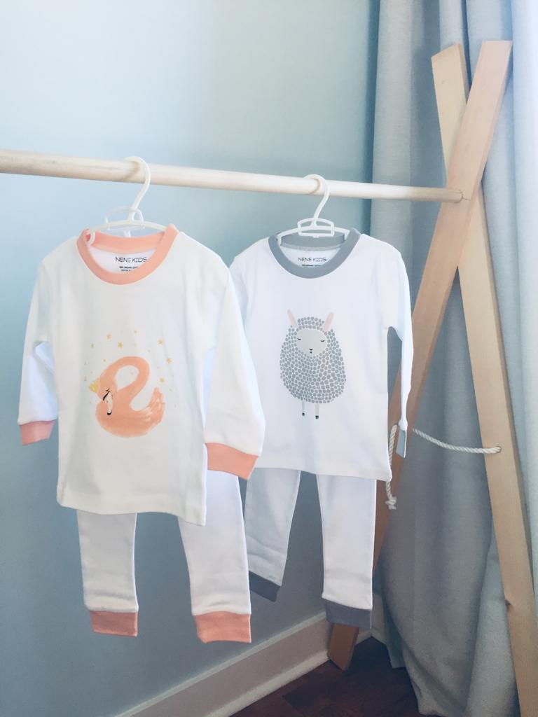Both Nene Kids pajama sets hanging side by side on a wooden clothing rack